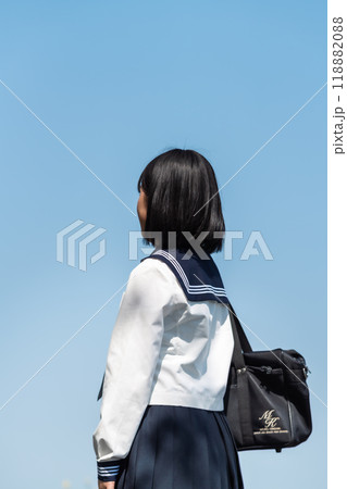 新学期を迎え通学路を登校する女子高生の後ろ姿 新学期を迎え通学路を登校する女子高生の後ろ姿 118882088