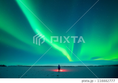 Tourist with red flashlight standing on snowy field 118882777