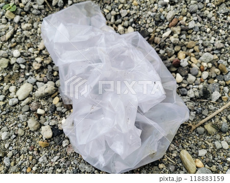 White plastic bag lying on sandstone, Used white plastic bags, plastic trash White plastic bag lying on sandstone, Used white plastic bags, plastic trash 118883159