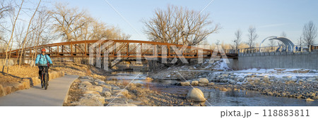 male cyclist is riding a bike in winter sunset scenery - Poudre River Trail in Fort Collins, Colorado at downtown whitewater park, recreation and commuting concept 118883811
