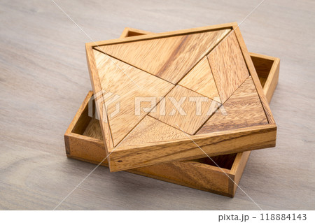 Tangram, a traditional Chinese Puzzle Game made of different wood parts to build abstract figures from them 118884143