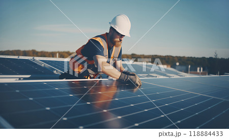 A man in work clothes on the roof is installing new ecological solar panels. Sustainable energy and sustainable development. Renewable energy. 118884433