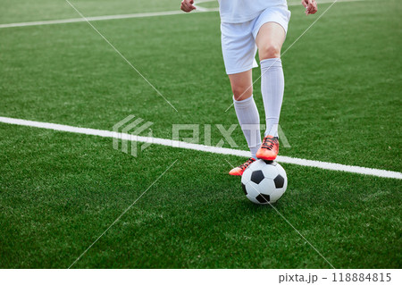 And the soccer player in the uniform and red clothes controlling the soccer ball on the Green Field And the soccer player in the uniform and red clothes controlling the soccer ball on the Green Field 118884815
