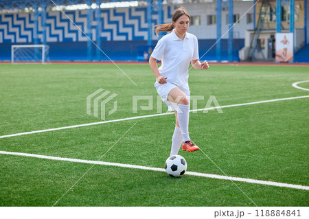 And the soccer player in the uniform and red clothes controlling the soccer ball on the Green Field And the soccer player in the uniform and red clothes controlling the soccer ball on the Green Field 118884841
