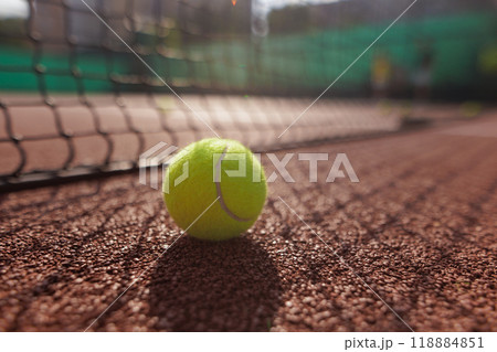 Tennis ball close up against tennis net on court background 118884851