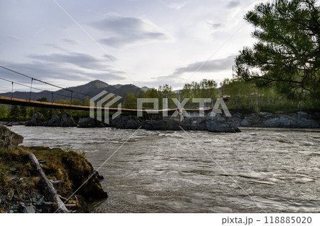 Elekmonar, Altai Republic, Suspension bridge over fast mountain river Katun. Sharp rocky islands in the middle of Katun river Elekmonar, Altai Republic, Suspension bridge over fast mountain river Katun. Sharp rocky islands in the middle of Katun river 118885020