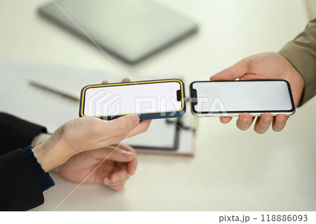 Young men sharing data or contact through their smartphone. Technology, data transfer, or collaboration Young men sharing data or contact through their smartphone. Technology, data transfer, or collaboration 118886093
