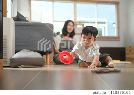 Little toddler boy playing with colorful toys on floor at home. Child development and learning concept 118886166