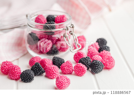 Sweet jelly candies in jar on white table. Sweet jelly candies in jar on white table. 118886567