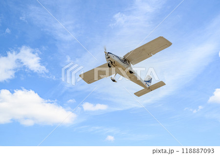 Single engine ultralight plane flying in the blue sky with white clouds	 118887093