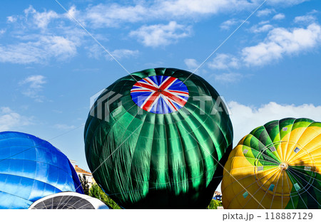 Colorful hot air balloon flying over blue sky with white clouds 118887129