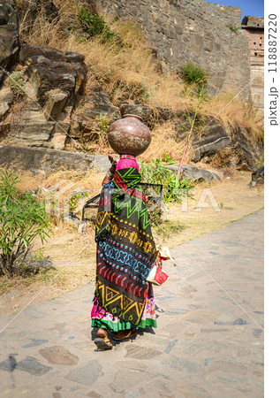 A village woman carrying pot of water on her head 118887220