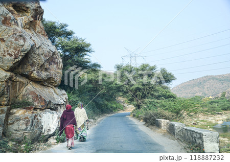 Two village women walking on the road in a rocky terraine Two village women walking on the road in a rocky terraine 118887232
