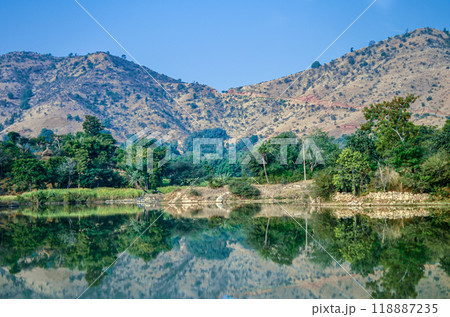 Reflection of trees and hills in a lake 118887235