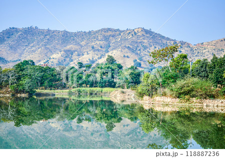 Reflection of trees and hills in a lake 118887236