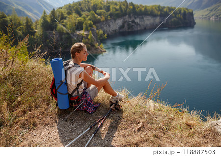 A Hiker Enjoying a Scenic Lake View During a Daytime Adventure in Natures Embrace A Hiker Enjoying a Scenic Lake View During a Daytime Adventure in Natures Embrace 118887503