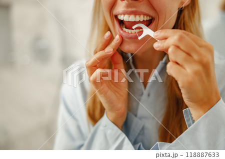 Flossing daily is vital for a beautiful smile and promoting overall health and hygiene Flossing daily is vital for a beautiful smile and promoting overall health and hygiene 118887633