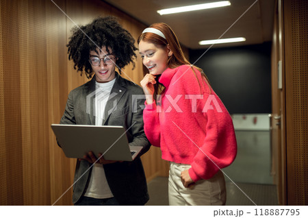 Two young people talking in the corridor and looking involved 118887795