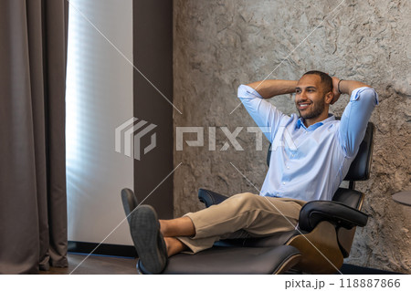 Businessman resting in chair with raised arms while having break 118887866