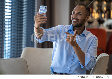 Businessman having online video communication in cafe while having break Businessman having online video communication in cafe while having break 118887889