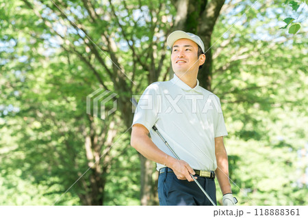 新緑の中でゴルフウェアを着た男性ゴルファー（ゴルフコース・アカデミー・会員権） 118888361