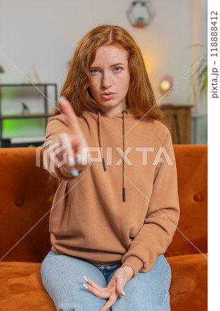 Displeased upset young woman sitting on sofa reacting to unpleasant awful idea, shake finger No Displeased upset young woman sitting on sofa reacting to unpleasant awful idea, shake finger No 118888412