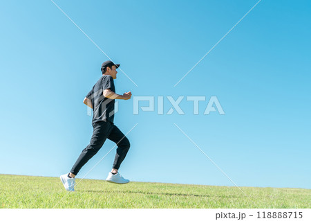青空の下でランニング・ジョギングをする男性（アスリート・有酸素運動・ワークアウト・フィットネス） 118888715