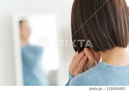 鏡を見て髪の毛を整える女性 118888881