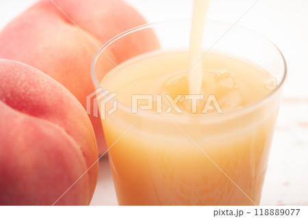 コップに注がれるピーチジュースのクローズアップ コップに注がれるピーチジュースのクローズアップ 118889077