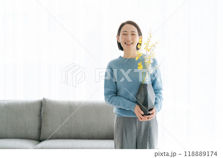 部屋にお花を飾る30代女性 118889174