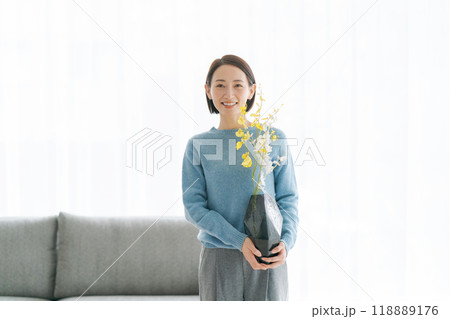 部屋にお花を飾る30代女性 118889176