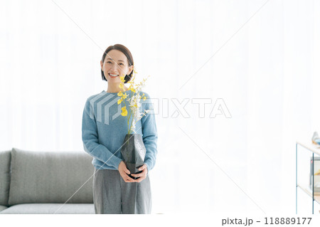 部屋にお花を飾る30代女性 118889177