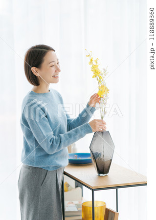 部屋にお花を飾る30代女性 部屋にお花を飾る30代女性 118889360