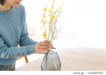 部屋にお花を飾る30代女性 118889362