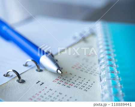 テーブルに置かれたカレンダーと手帳 118889441