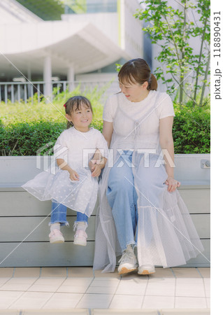 街中で寄り添って座る親子 118890431