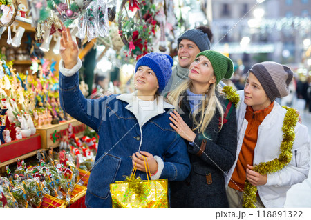 Friendly family chooses Christmas souvenirs and toys Friendly family chooses Christmas souvenirs and toys 118891322