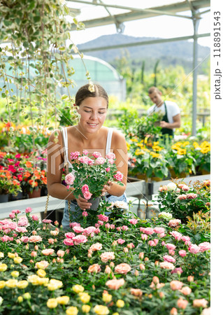 Young woman choosing bush roses in flower shop 118891543