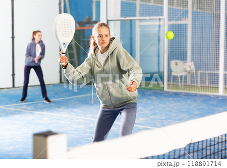 Young girl with racquet playing padel 118891714
