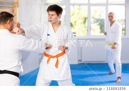 Adult and young men training karate fight Adult and young men training karate fight 118891856