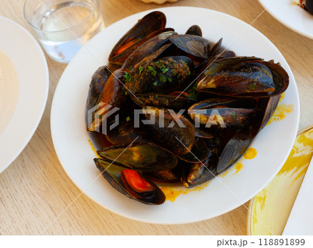 Delicious boiled mussels with tomato sauce and parsley Delicious boiled mussels with tomato sauce and parsley 118891899