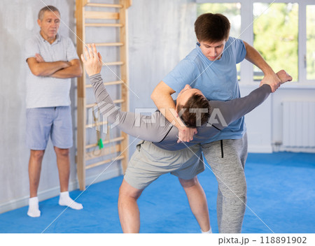 Adult and young men training self-defense techniques Adult and young men training self-defense techniques 118891902