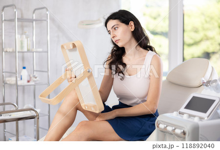 woman gazes at herself in mirror woman gazes at herself in mirror 118892040