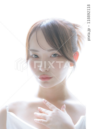 朝日を浴びてスキンケアをしている若い女性 118892118