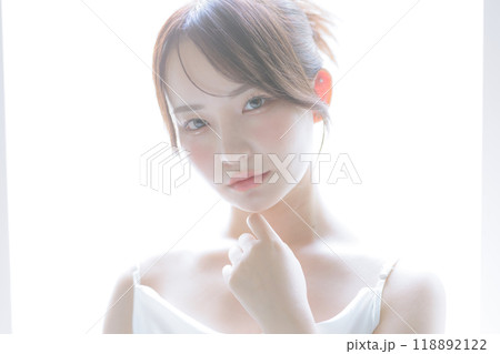 朝日を浴びてスキンケアをしている若い女性 118892122