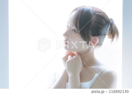 朝日を浴びてスキンケアをしている若い女性 朝日を浴びてスキンケアをしている若い女性 118892130
