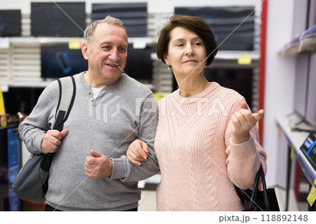 Middle aged man and woman choosing TV in electronic store Middle aged man and woman choosing TV in electronic store 118892148