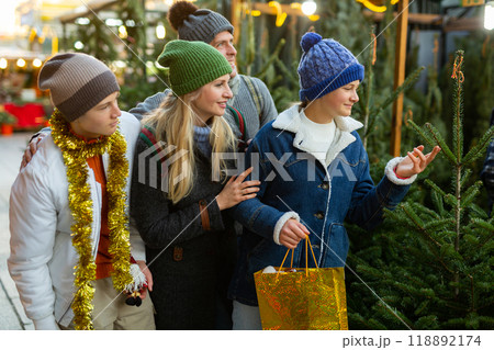 Family choosing christmas tree at fair 118892174