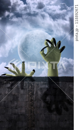 Witch hands reaching out from wall with full moon background, trying to grab something or someone. Scene is scary and creepy. Evil, satan, zombie or a monster hand 118892671