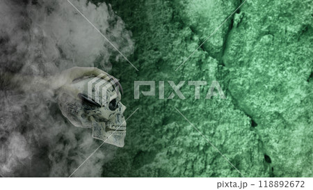 Witch hand with long black nail holding human head skull through smoke, gives the image a spooky and scary mood 118892672